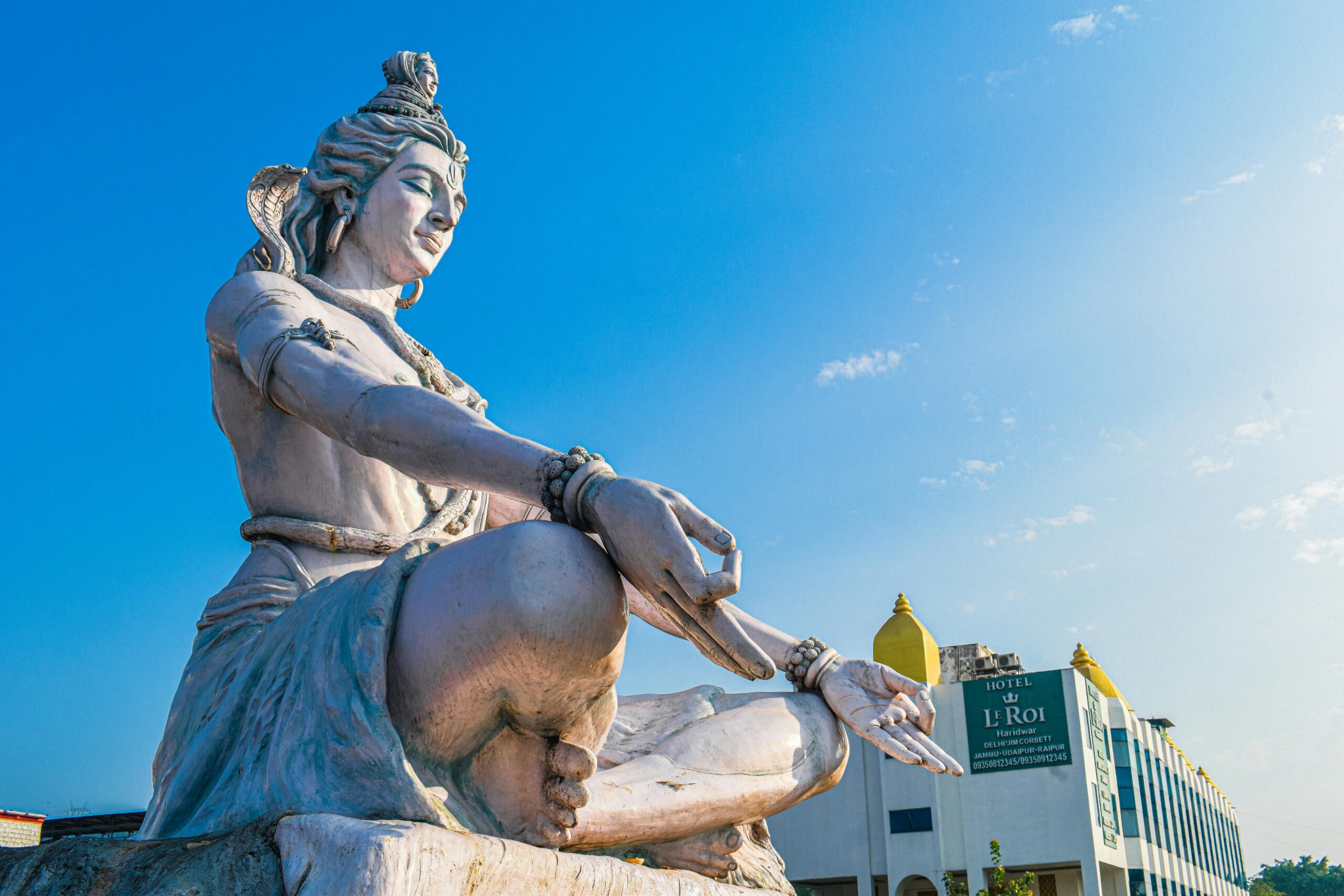 Magnificent low-angle view of Lord Shiva statue against a blue sky in Haridwar, India.