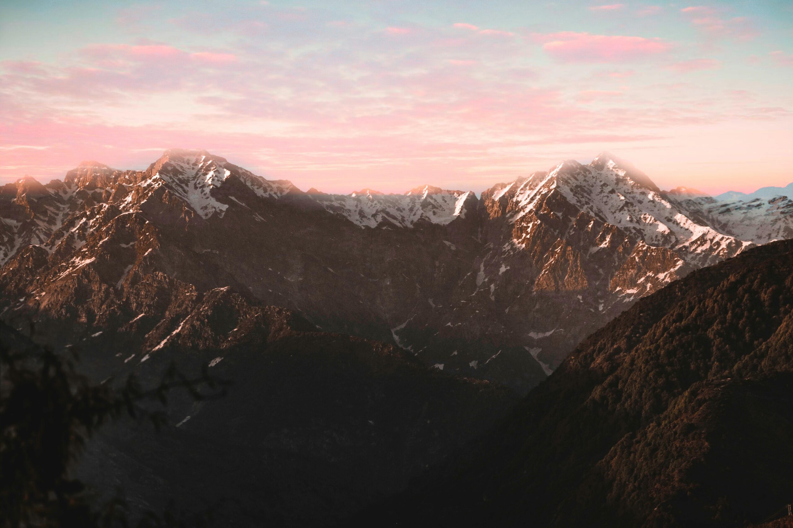 Breathtaking view of snow-covered mountains with a vibrant sunset sky.
